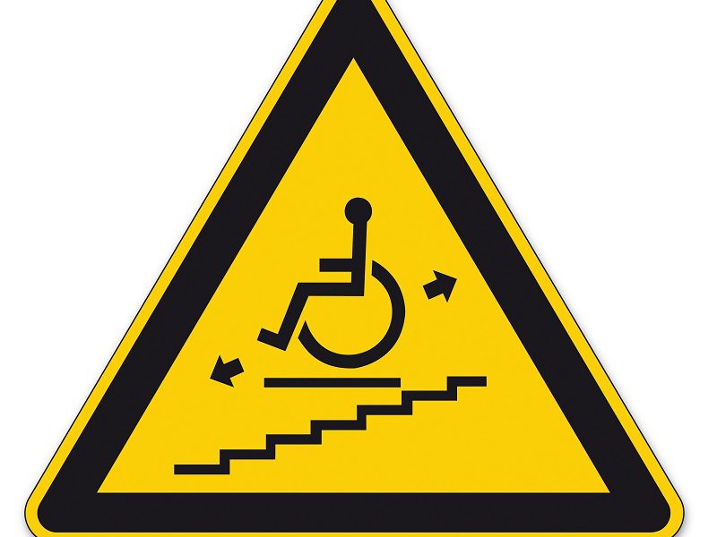 Triangular caution sign indicating wheelchair ramp or accessible route ahead.