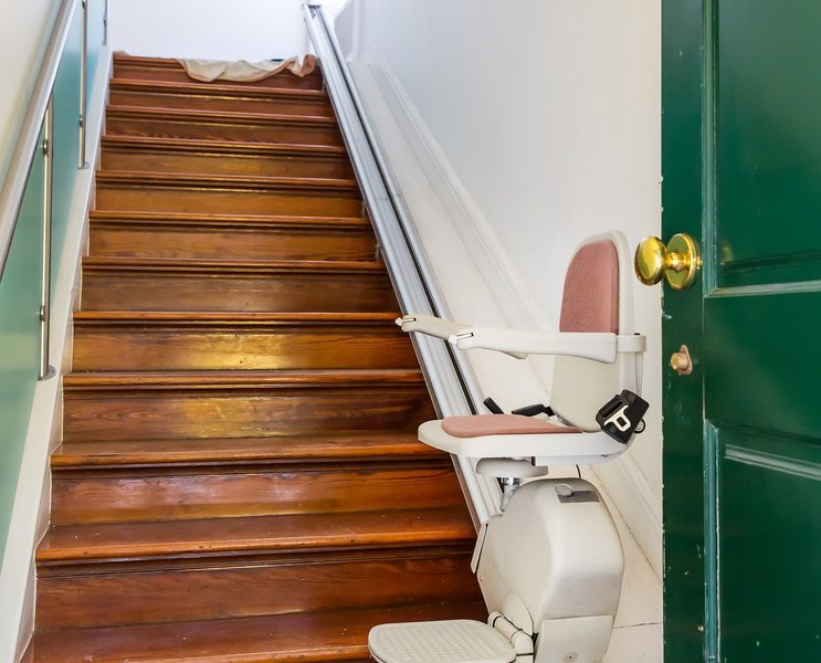 Stairlift installed on a wooden staircase in a home.