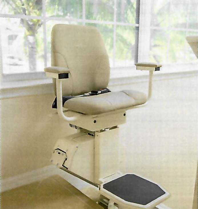 An empty stairlift installed in a home, with the seat and footrest in the resting position.