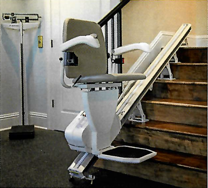 A stairlift installed on a staircase, with the chair and footrest in the position for use.