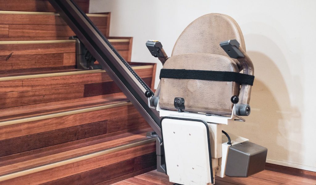 A stairlift installed on a wooden staircase in a home.
