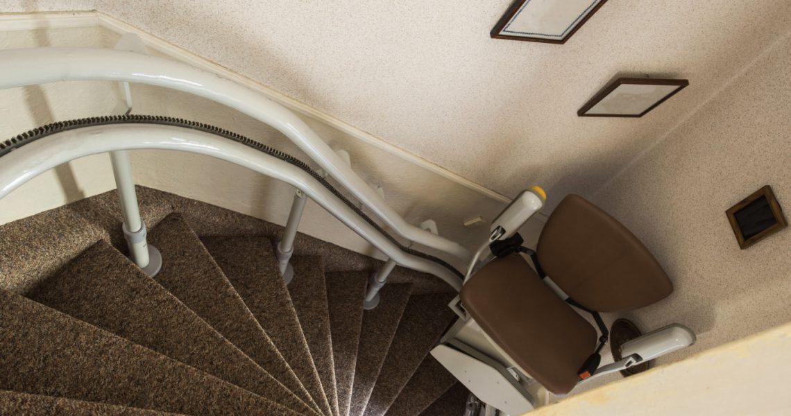 An empty stairlift installed on a residential staircase.