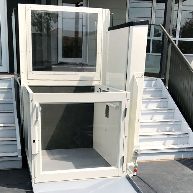 An outdoor platform wheelchair lift with its doors open.